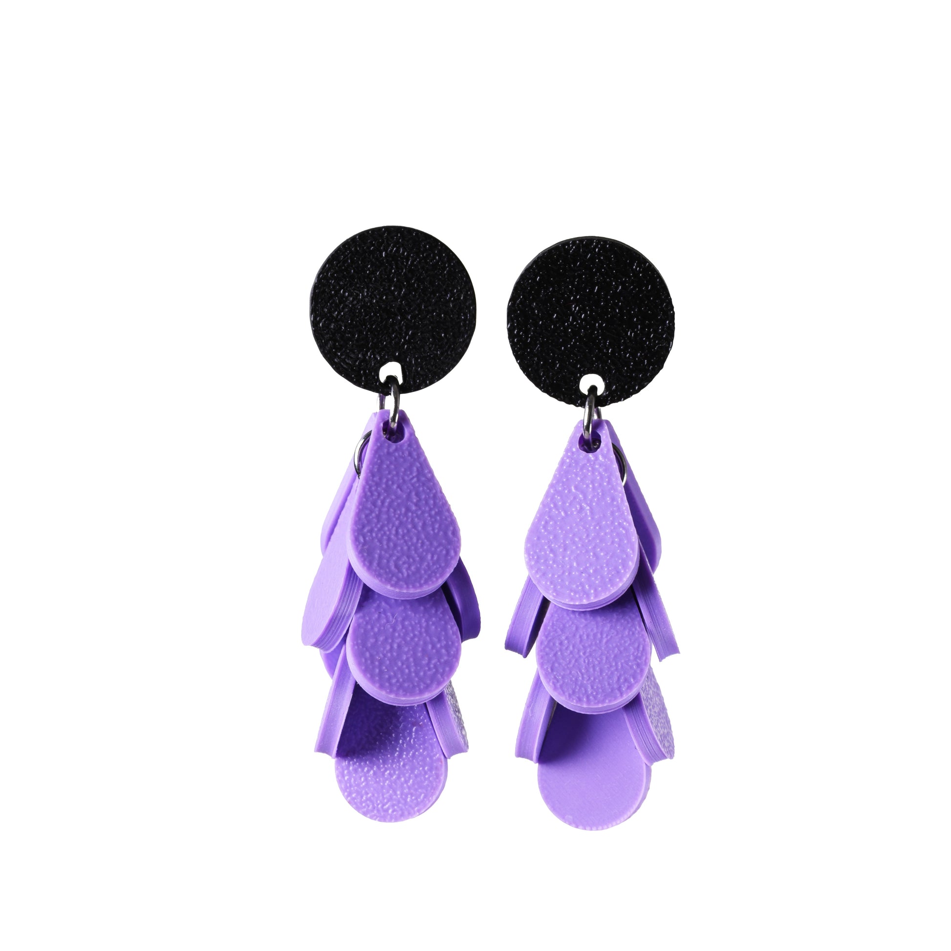 Pair of earrings with black circular tops and purple layered designs on a white background